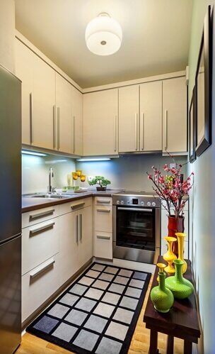 A small kitchen space, painted white, can help it seem larger. 